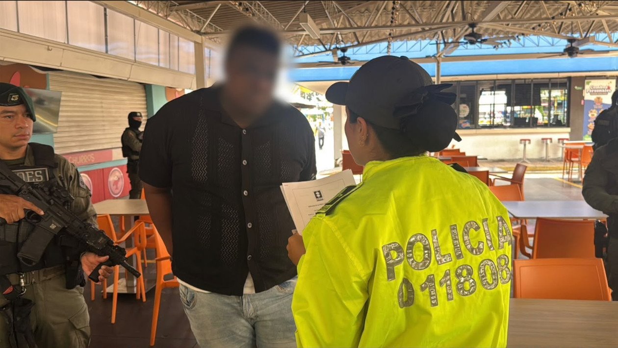 Una agente de la Policía lee un documento frente al capturado, con integrantes del GOES alrededor